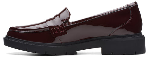 A dark red patent leather loafer with a black lug sole.