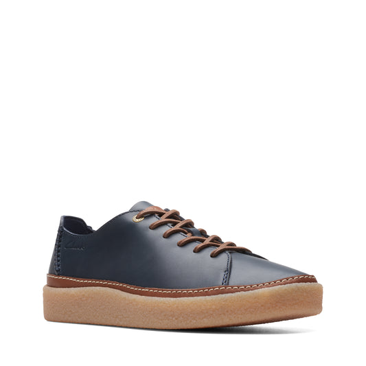 Low-profile navy blue leather sneaker with light brown laces and a thick, light brown sole.