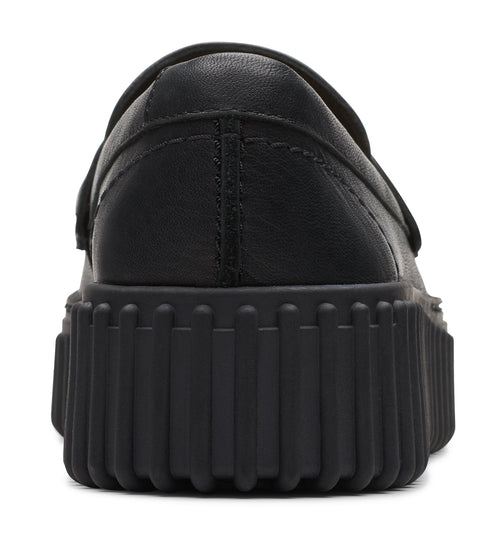 Black slip-on loafer showing the heel of the shoe and its thick, ridged sole.
