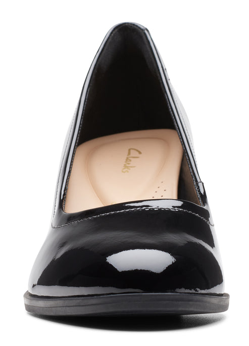 Black patent leather dress pump with round toe and beige insole.