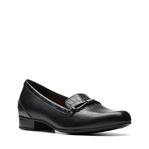 Close-up of a black loafer with a mock croc texture on the vamp and a bow detail.