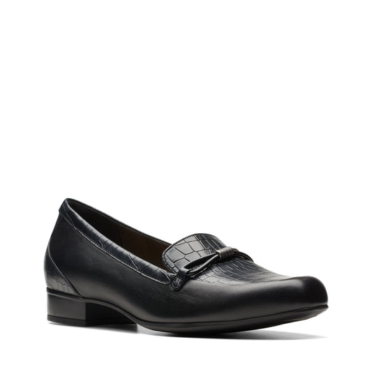 Close-up of a black loafer with a mock croc texture on the vamp and a bow detail.