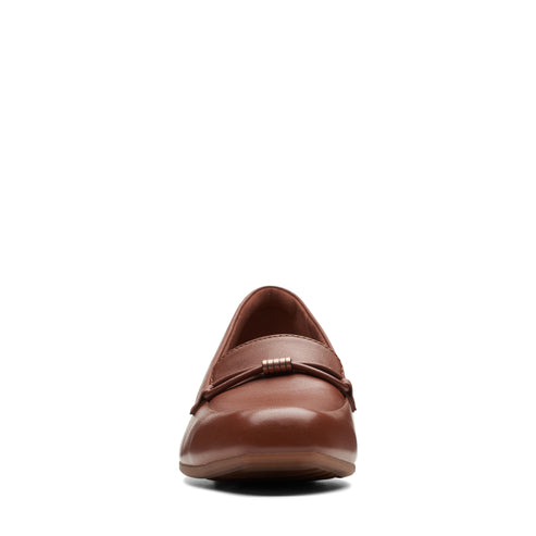 A brown leather loafer with a decorative metal bar across the top.