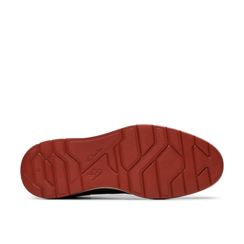 The bottom of a brown shoe with a red sole featuring a geometric pattern.