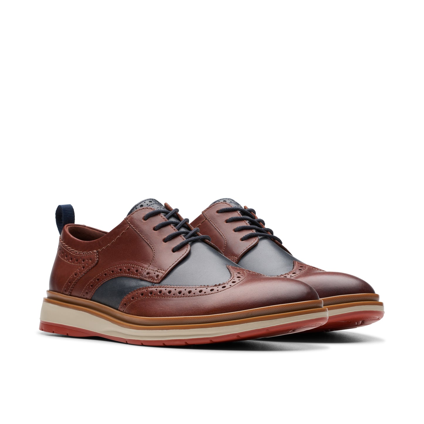 A pair of brown leather wingtip oxford shoes with a thick sole.