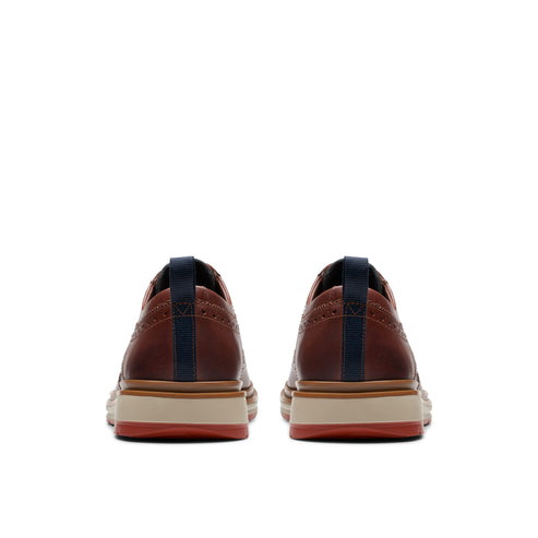 Pair of burgundy dress shoes, rear view, with blue pull tabs and a striped sole.