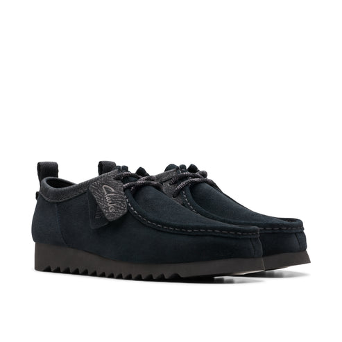 Pair of navy suede moccasin shoes with gray laces and textured tongue patch.