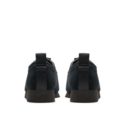 Rear view of two black suede shoes with matching heel, lace-up.