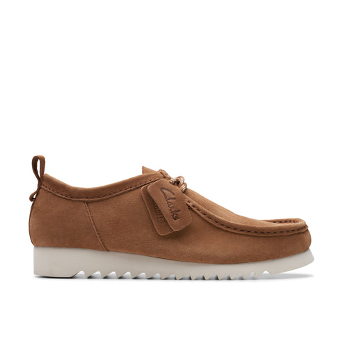 Tan suede shoe with textured white sole and small attached logo tag.