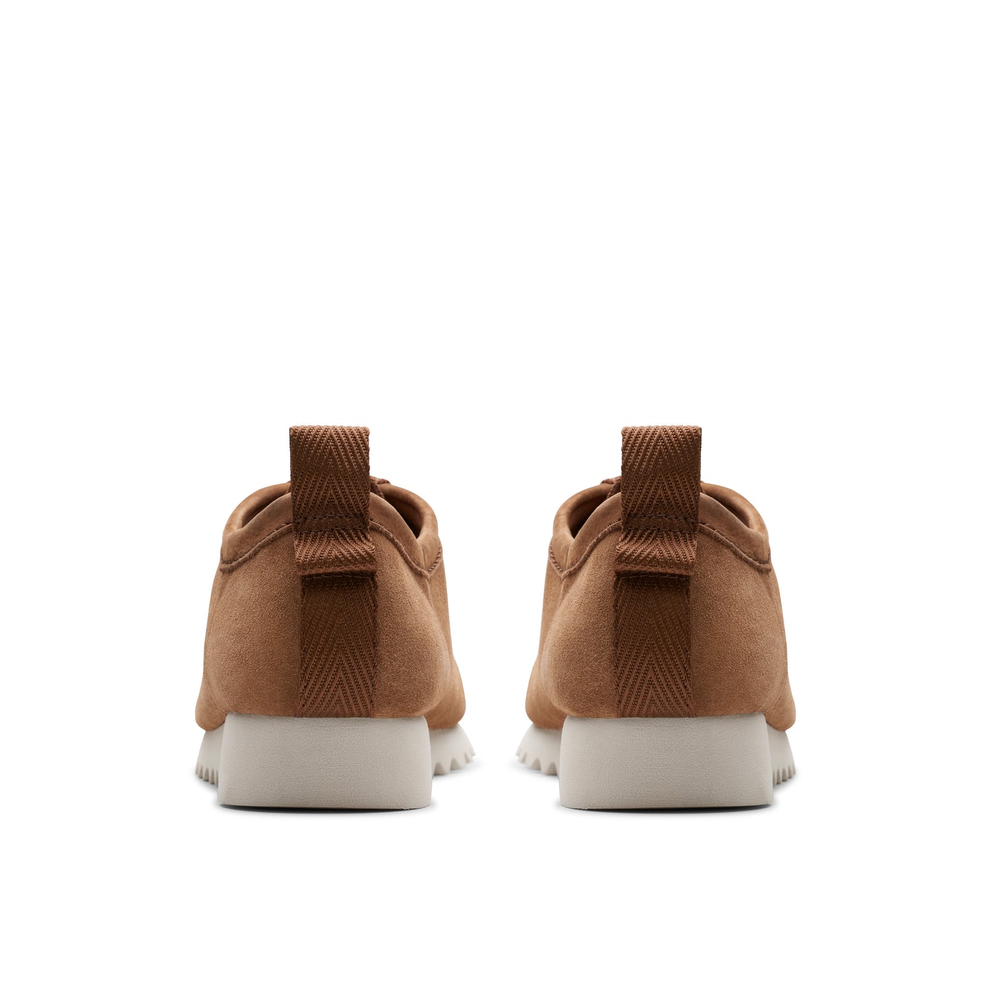 Rear view of two brown suede casual shoes with white soles.