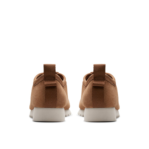Rear view of two brown suede casual shoes with white soles.
