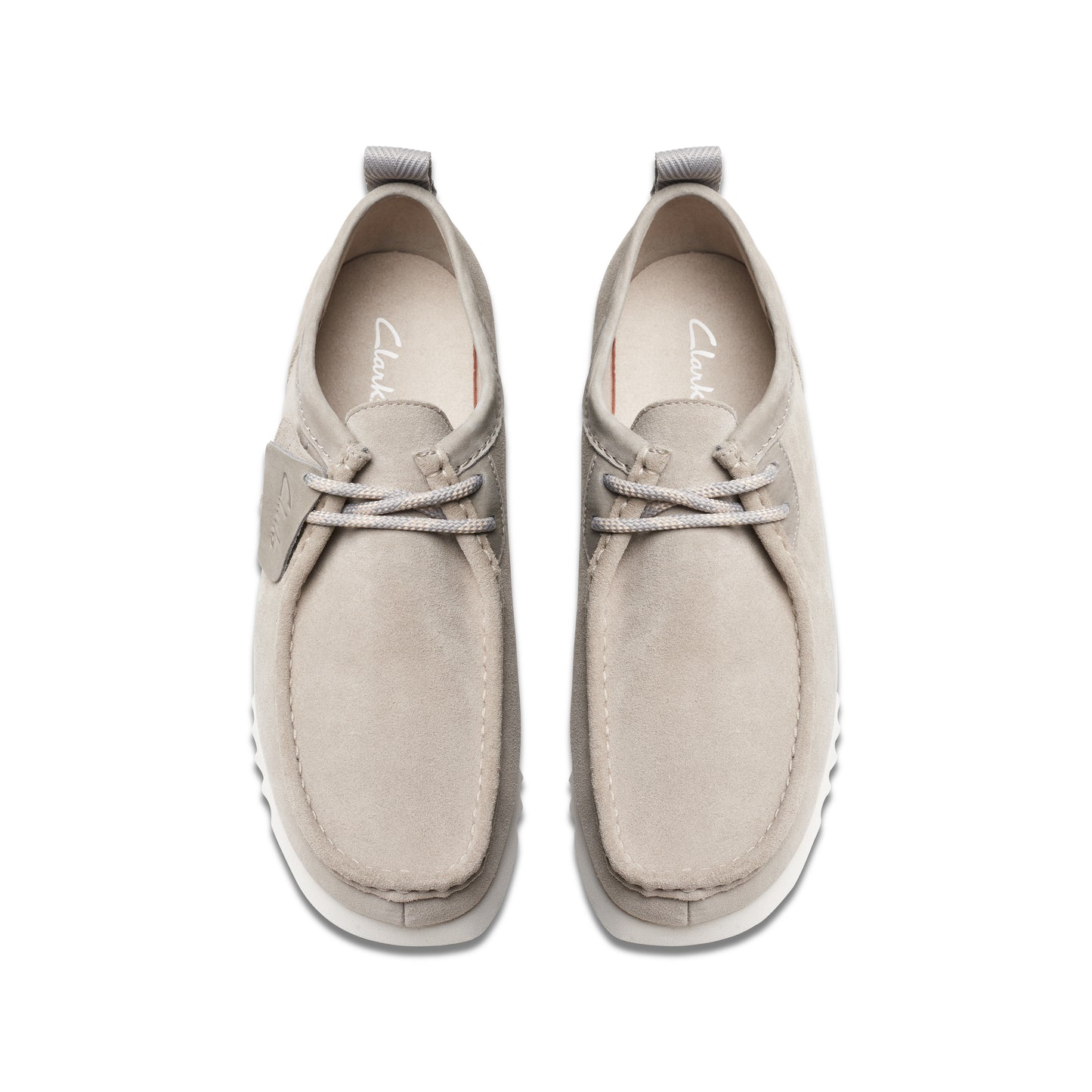 Overhead view of two gray nubuck leather lace-up shoes with a white sole.