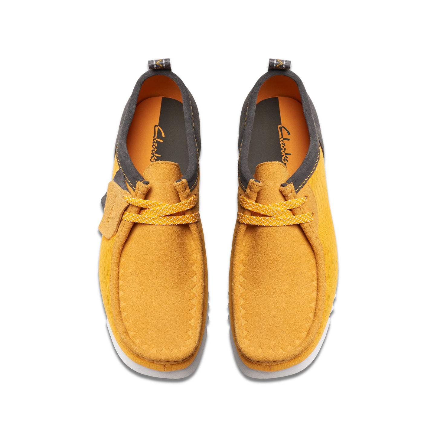 Overhead view of mustard-yellow nubuck shoes with off-white soles and dark-gray trim.