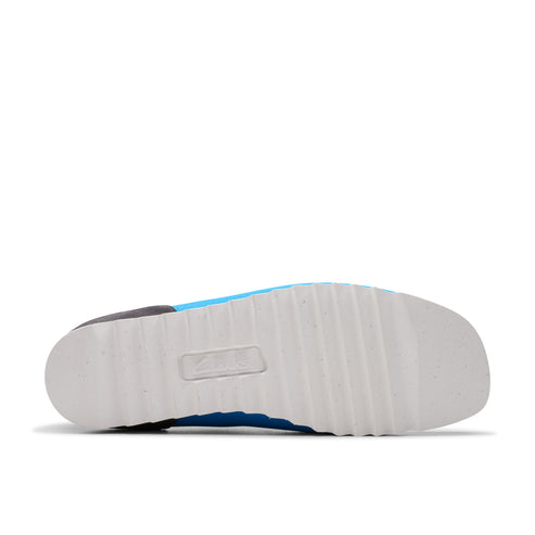 A bottom view of a shoe with a thick, white sole that has a textured pattern.