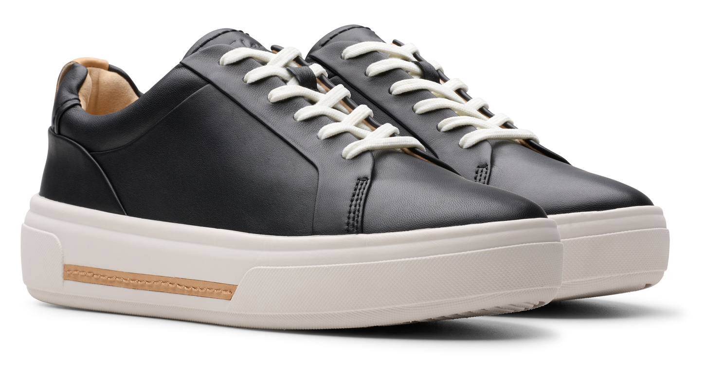 Black leather sneaker with white laces and platform sole.