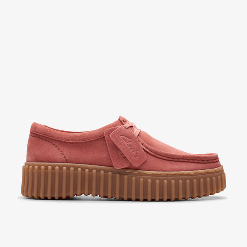 Side view of a platform, flat, pink suede shoe with brown treaded rubber outsole.