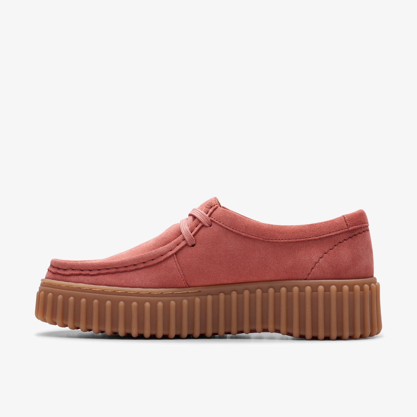 Low top pink suede shoe with a ribbed brown platform sole.