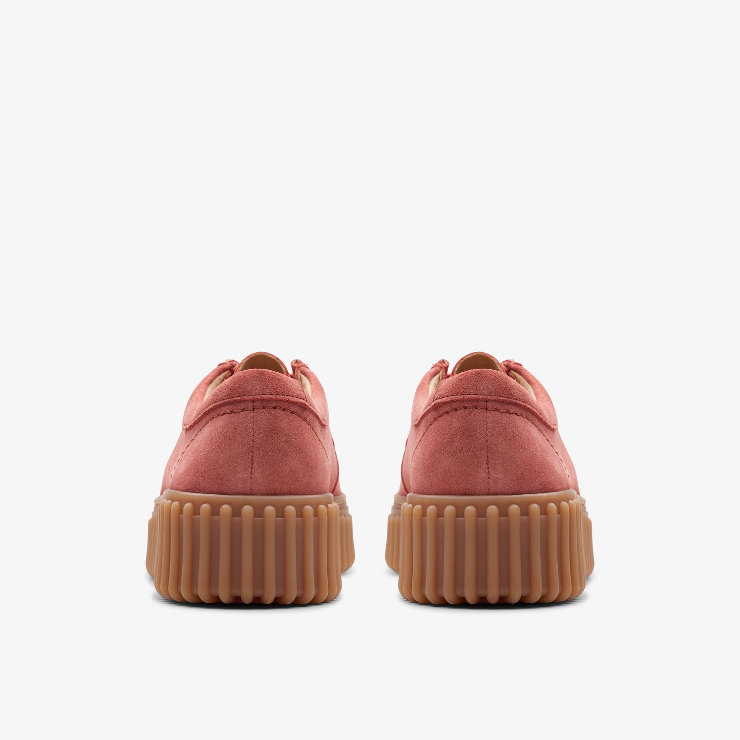 View of the rear of two red suede flat shoes with brown ridged soles.