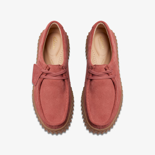 Top-down view of two rose-colored suede shoes with thick, ridged crepe soles and matching laces.