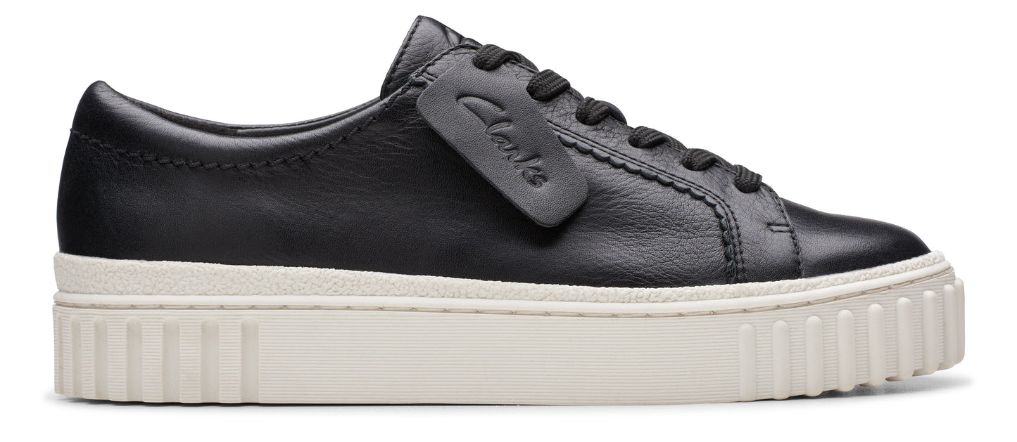 A black leather sneaker with a thick, white platform sole and a matching black tongue tag.