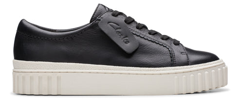 A black leather sneaker with a thick, white platform sole and a matching black tongue tag.