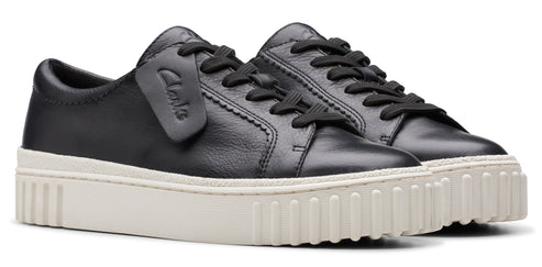 A pair of black leather sneakers with white soles and black laces.