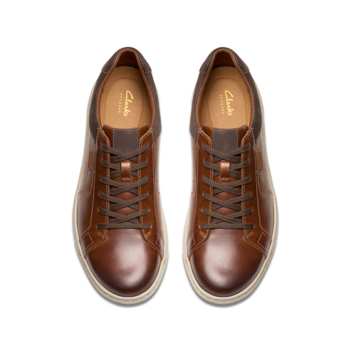 Pair of brown leather lace-up shoes with light-colored soles, shot from above.