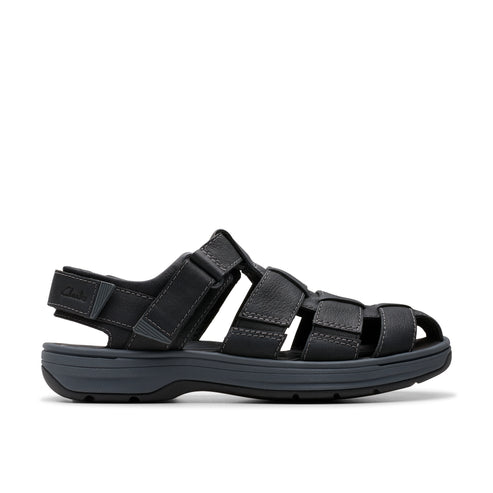A low profile dark gray sandal with a flat heel, featuring woven straps and an adjustable heel strap.