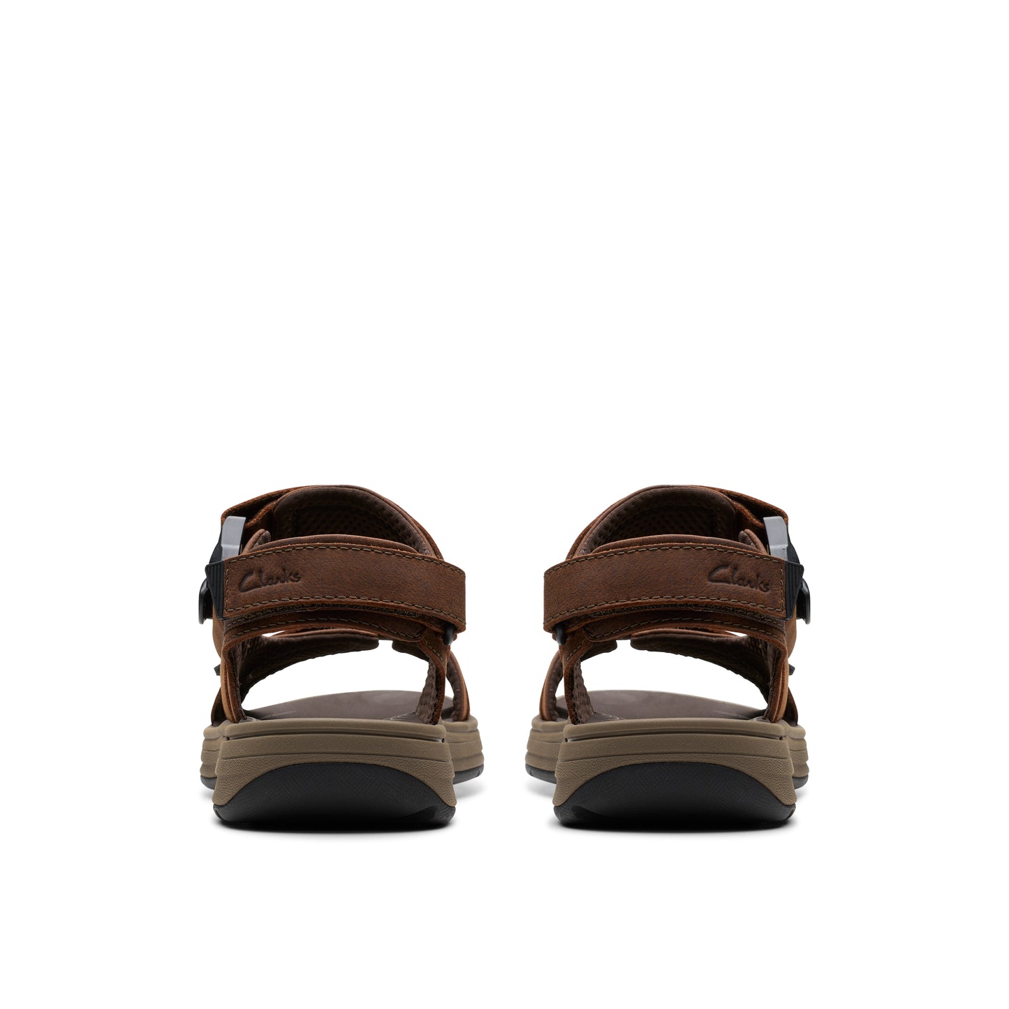 Rear view of two brown leather sandals with black velcro straps, showing their thick, dark soles.