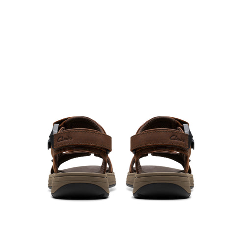 Rear view of two brown leather sandals with black velcro straps, showing their thick, dark soles.