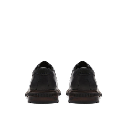 Pair of black leather dress shoes, rear view.