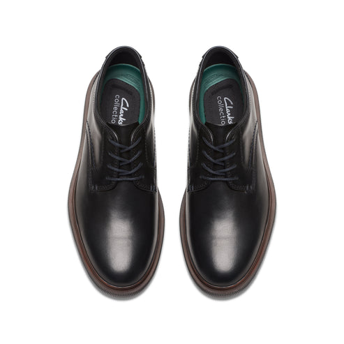 Pair of black leather dress shoes with laces, visible green insole.