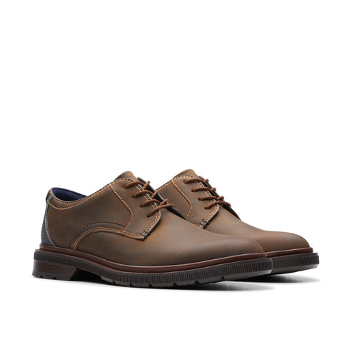 Pair of brown leather dress shoes with stitched detailing.