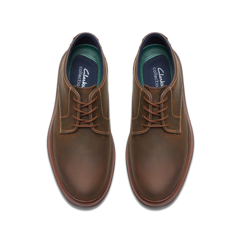 A pair of brown leather dress shoes with matching laces.