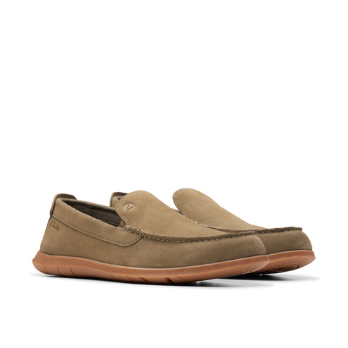 A pair of olive green slip-on shoes with brown soles.