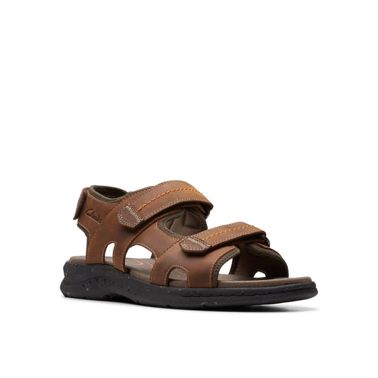 A brown leather sandal with velcro straps and a black sole.