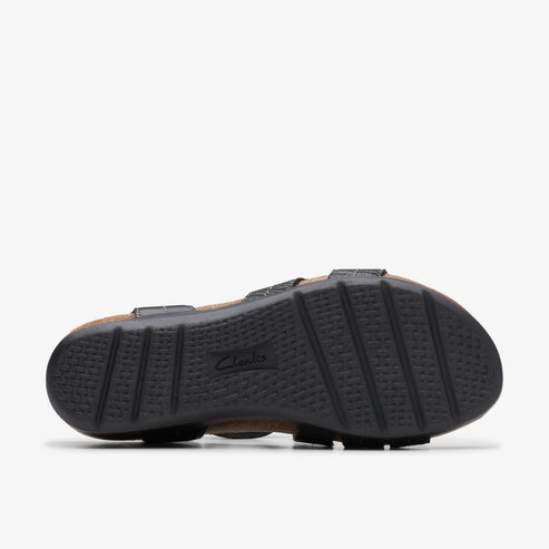 Bottom of a sandal with black, grooved rubber soles and visible "Clarks" brand label.
