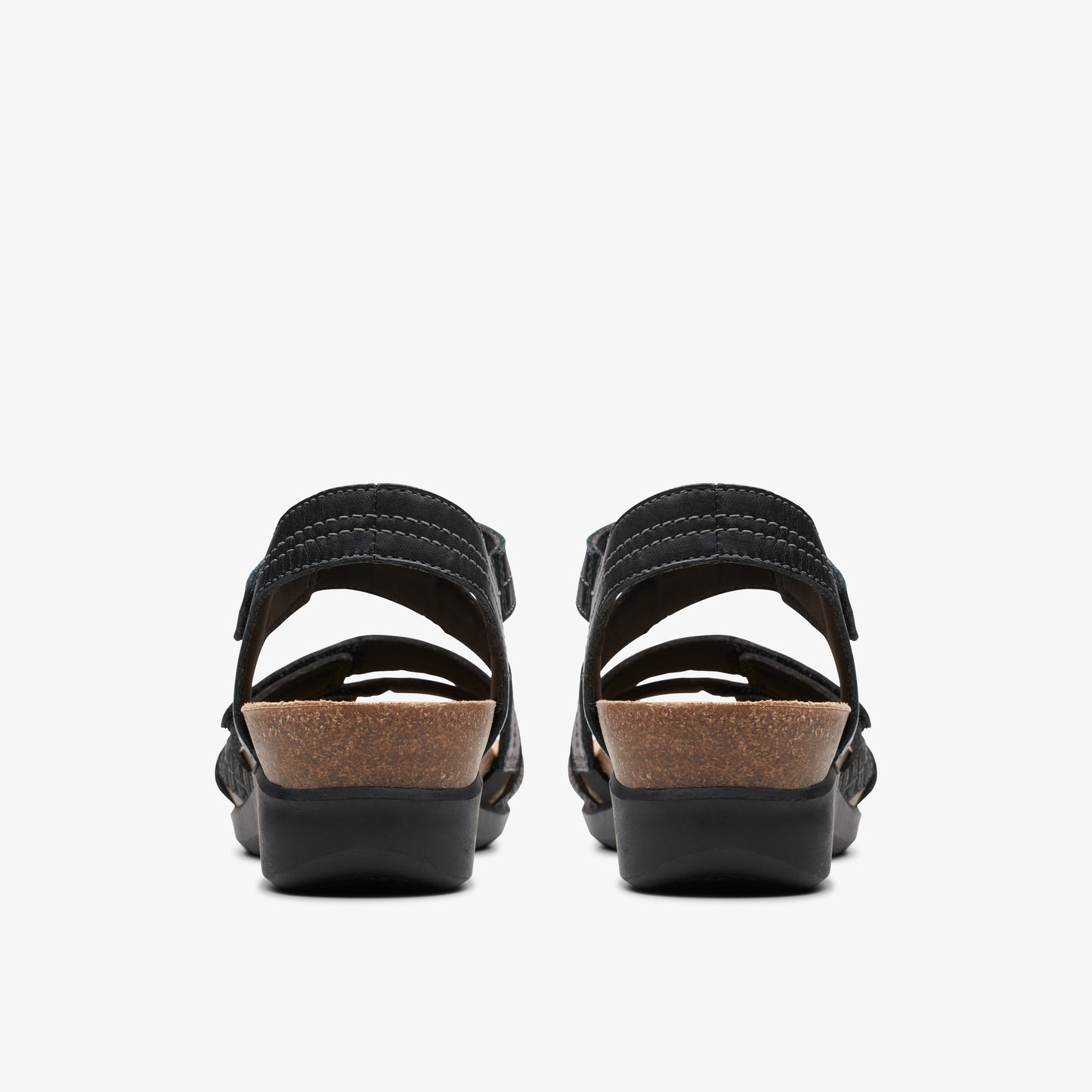 Pair of black sandals with cork platforms, viewed from the rear.