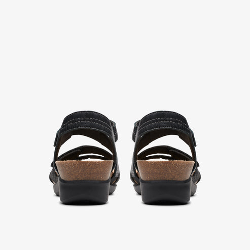 Pair of black sandals with cork platforms, viewed from the rear.