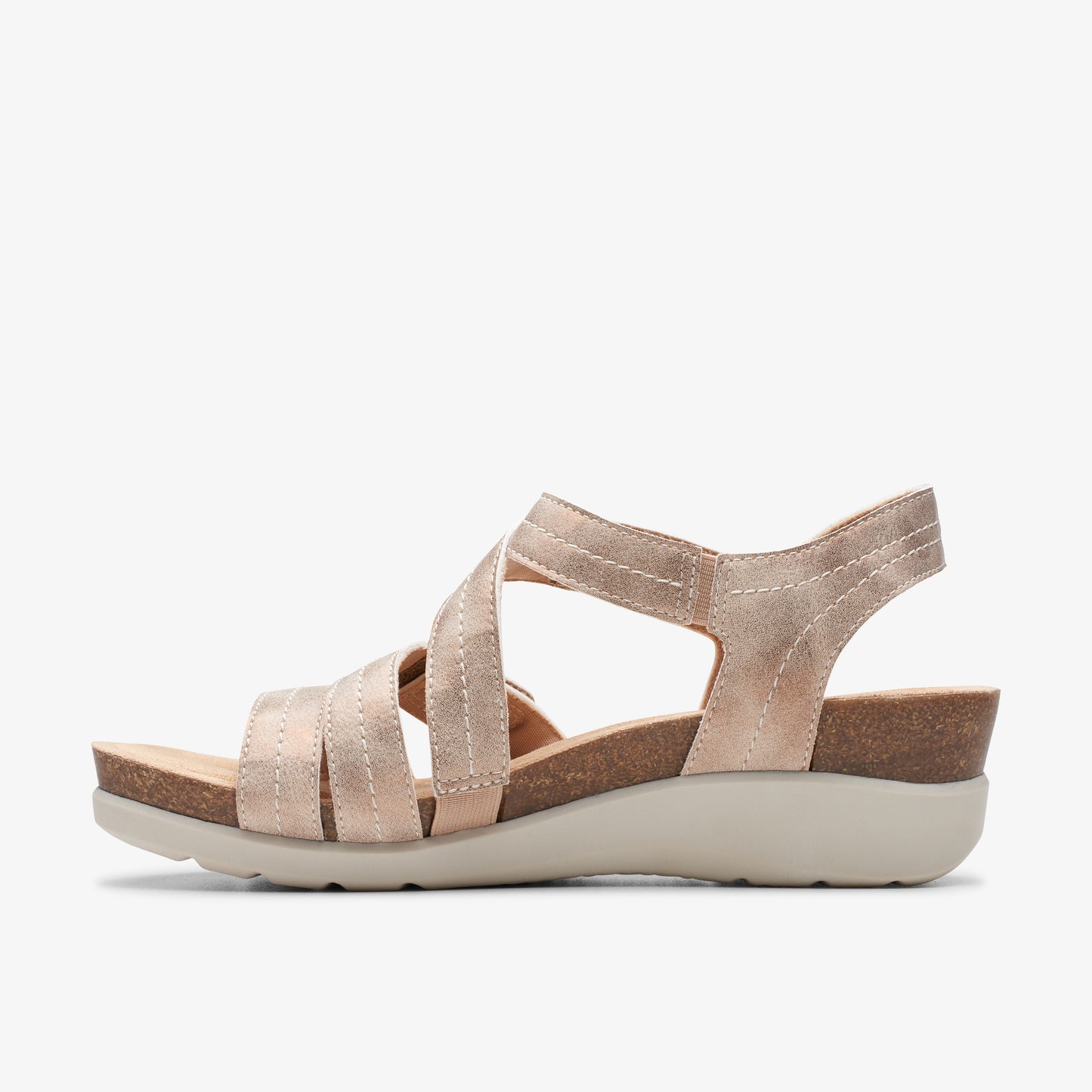 Gold sandal with criss-cross straps and a low wedge heel.