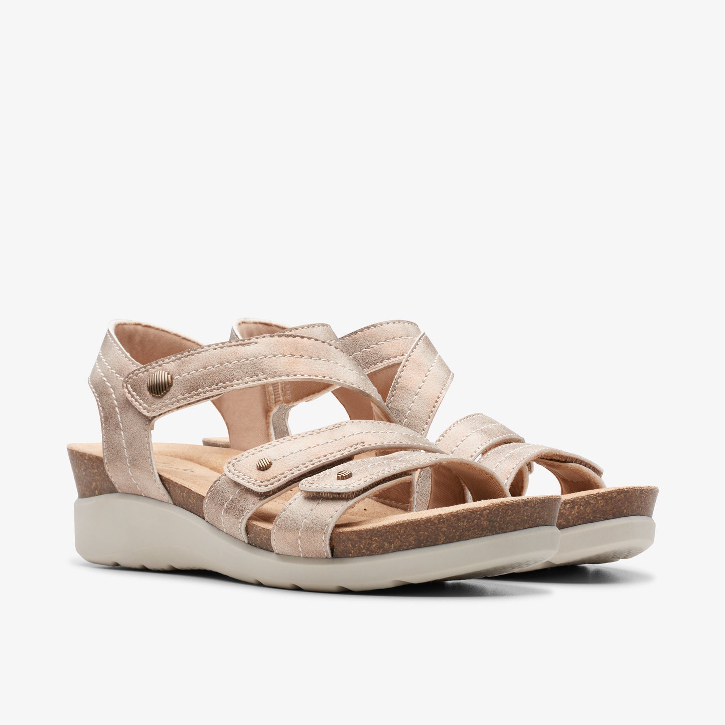 Pair of women's flat, champagne-colored sandals with straps and velcro closures.