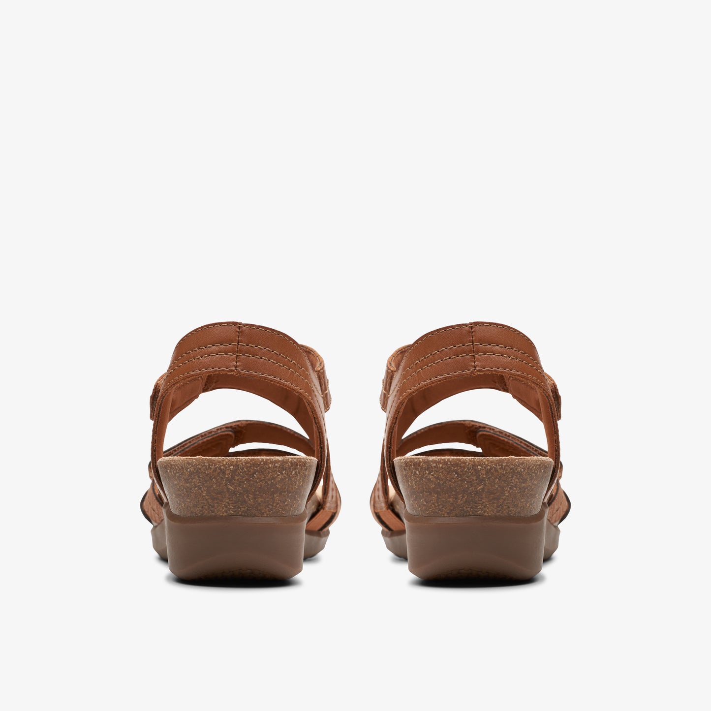 Pair of brown open-toe sandals with adjustable straps and low wedge heels.