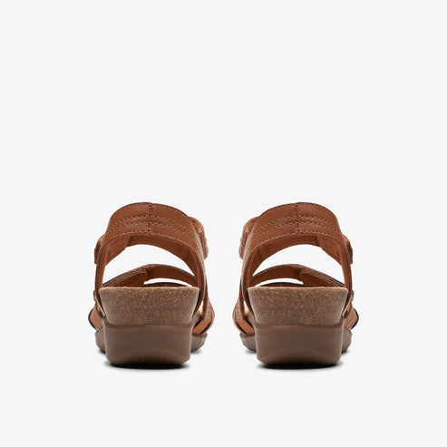 Pair of brown open-toe sandals with adjustable straps and low wedge heels.