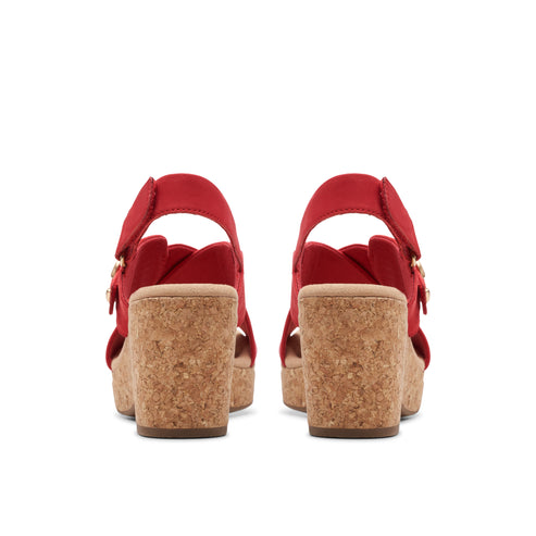 Red wedge sandals with cork heels and buckle straps, rear view.