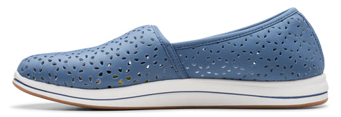 A blue slip-on shoe with a white sole and floral cutouts.