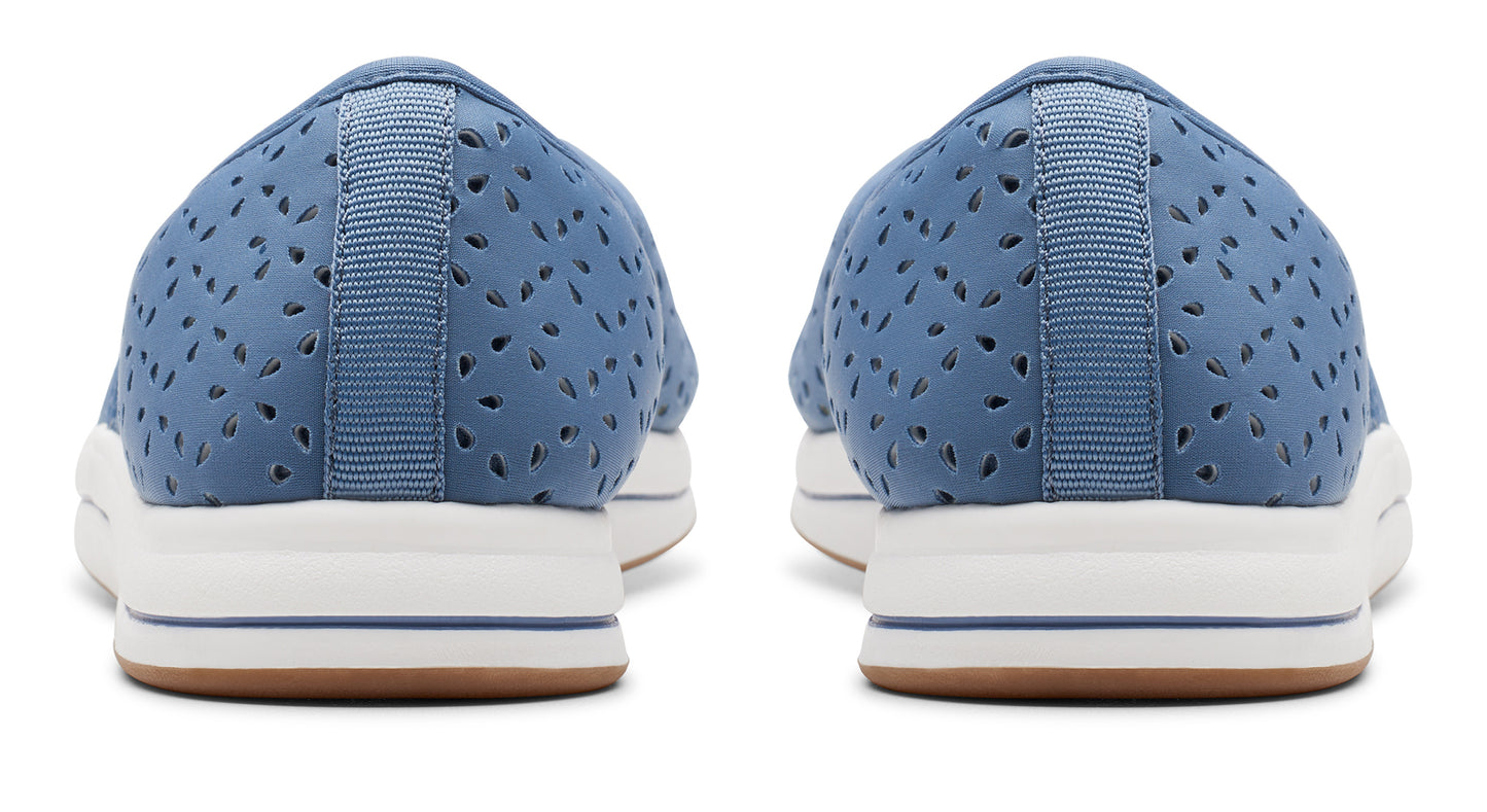 Rear view of a pair of light blue perforated slip-on shoes with white platform soles and brown outsoles.