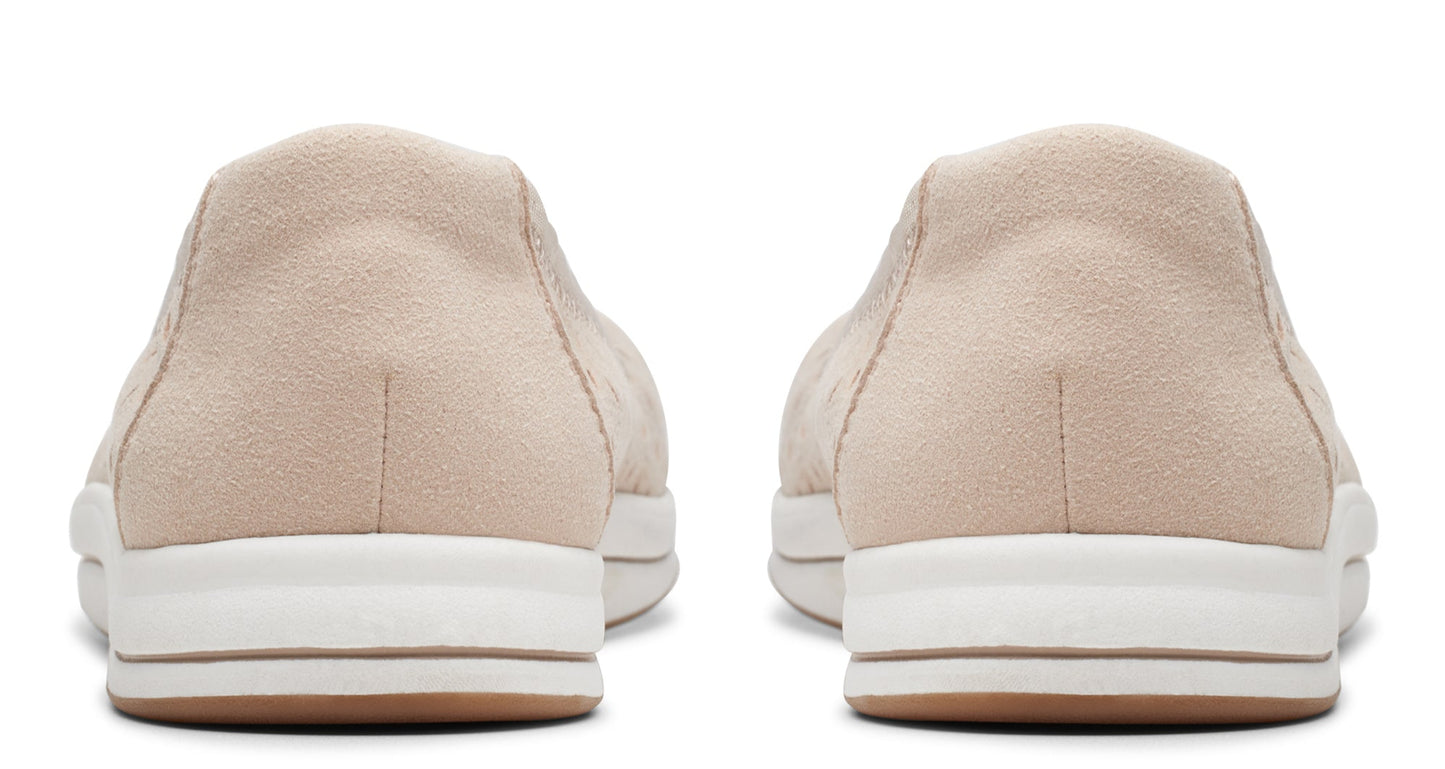 Back view of neutral suede slip-on shoes with thick, white soles and brown accents.