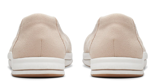Back view of neutral suede slip-on shoes with thick, white soles and brown accents.