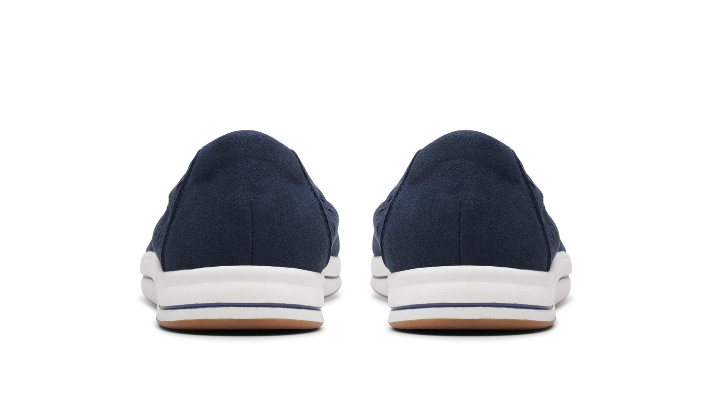 Rear view of two navy blue slip-on shoes with white soles.