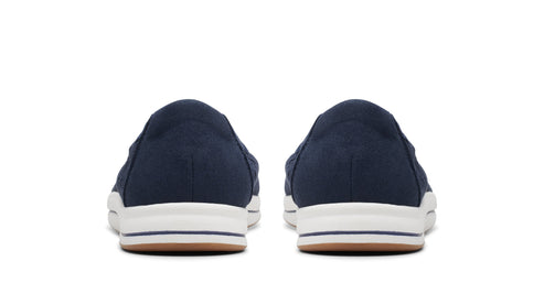 Rear view of two navy blue slip-on shoes with white soles.